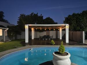 a swimming pool in a backyard with a pergola at Opulent Escape Secret Nest in Gqeberha