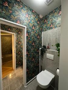 Un baño con inodoro y papel pintado de flores. en Attraktives City-Apartment No4, en Bremen