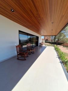 a patio with chairs and a table under a wooden ceiling at Casa Arara in Espirito Santo Do Pinhal