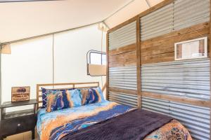 ein Schlafzimmer mit einem Bett und einer Holzwand in der Unterkunft Cozy Old West Retreat by Tombstone in Tombstone