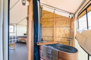 ein Badezimmer mit Badewanne in einem Minihaus in der Unterkunft Cozy Old West Retreat by Tombstone in Tombstone