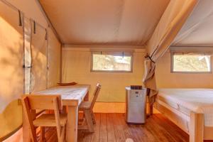 - une salle à manger avec une table et un lit dans une petite maison dans l'établissement Glamping Getaway on Winery in Hill Country, à Johnson City