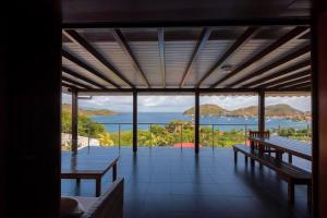 a room with benches and a view of the ocean at Villa Mangouste in Terre-de-Haut