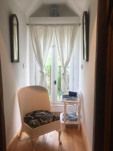 einen Stuhl und einen Tisch in einem Zimmer mit Fenster in der Unterkunft Beauval Zoo & Châteaux, 2 bedroom house in La Celle-sous-Gouzon