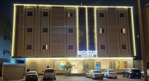 a building with cars parked in a parking lot at اجنحة دانة DANAT Suites الرياض حي اليرموك in Riyadh