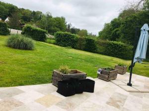 eine Terrasse mit zwei Pflanzen und einem Sonnenschirm in der Unterkunft Beauval Zoo & Châteaux, 2 bedroom house in La Celle-sous-Gouzon