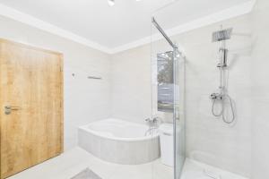 a bathroom with a tub and a toilet and a shower at Attraktive Neubauwohnung in Bremen +12 photos