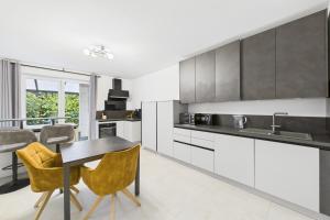 a kitchen with white cabinets and a table and chairs at Attraktive Neubauwohnung in Bremen
