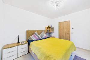 a bedroom with a bed with a yellow bedspread at Attraktive Neubauwohnung in Bremen