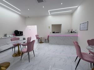 a waiting room with pink chairs and a counter at Hotel Margot in Milan