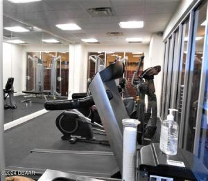 a gym with a treadmill and a bike in it at Spectacular Ocean View in Daytona Beach