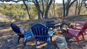 trois chaises et une table avec un foyer dans l'établissement Hill Country Glamping with Unforgettable Skies, à Boerne