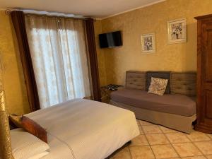 ein Schlafzimmer mit einem Bett und einer Couch und einem Fernseher in der Unterkunft B&B Da Isa 