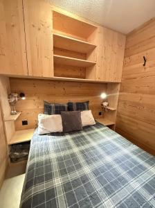 une chambre avec un lit dans une pièce aux murs en bois dans l'établissement Appartement au pied des pistes, à Châtel 9 autres photos