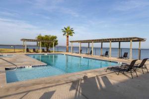 a swimming pool with chairs and a view of the ocean at Settle Into a Cozy Lakeside Glamping Escape in Onalaska