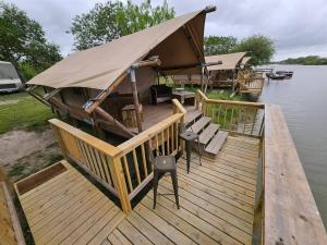 a boat with a tent on a dock on the water at Safari Tent Retreat by SpaceX & Boca Chica Beach! in Colonia Acres