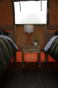 a bedroom with two beds and a table with a lamp at Boutique Safari Tent Near SpaceX Launch Site in Colonia Acres +15 photos