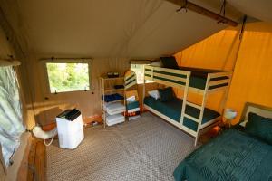 a room with two bunk beds in a tent at A Calm and Cozy Lakeside Glamping Retreat Awaits in Onalaska