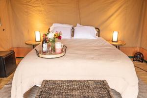 een bed in een tent met een dienblad met bloemen erop bij Cozy Wine Country Retreat at Painted Prairie in Currie