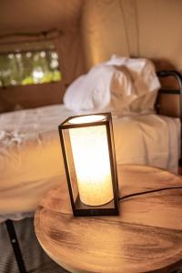 een lamp op een houten tafel met een bed bij Cozy Wine Country Retreat at Painted Prairie in Currie