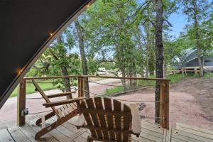a wooden porch with a bench and a fence at Escape to Cloud Nine Glamping in the Black Hills in Keystone +25 photos
