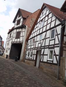 a black and white building next to a brick street at Monteurs-Ferienwohnung in Wolfhagen
