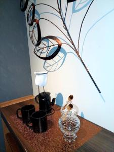 a wooden table with a glass vase and black pots at studio estilo industrial Centro in Campos dos Goytacazes +10 photos