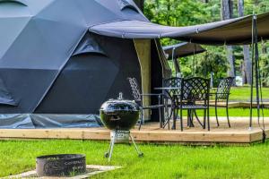 a large tent with a grill in the grass at Luxury Catskill Mountains Dome Retreat in Gilboa