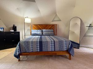a bedroom with a bed with a blue and white comforter at Peaceful Dome Getaway in the Catskills in Gilboa
