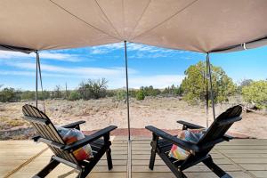 two people sitting in chairs under an umbrella at Winter Nights in a Secluded Canyon Dome in Valle