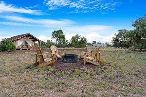 a group of chairs sitting around a fire in a field at Winter Nights in a Secluded Canyon Dome in Valle