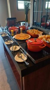 Un buffet con muchos tipos diferentes de comida en una mesa. en Hotel C jaguariuna, en Jaguariúna
