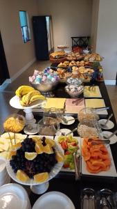 Una mesa con muchos tipos diferentes de comida sobre ella. en Hotel C jaguariuna, en Jaguariúna 16 fotos más