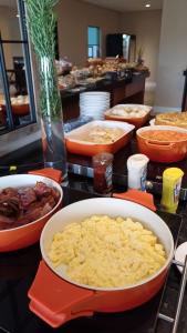 Un buffet con tazones de comida en una mesa. en Hotel C jaguariuna, en Jaguariúna