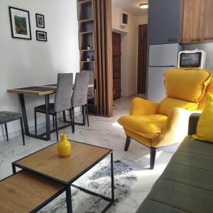 ein Wohnzimmer mit einem gelben Sofa und einem Tisch in der Unterkunft Cera avangarda apartment in Bukorovac