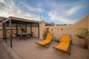 Station Bab FtouhDar Na的阳台上设有带桌椅的露台