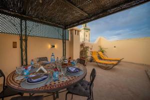 a table with plates and glasses on a patio at Dar Na in Station Bab Ftouh