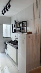 una cucina bianca con frigorifero e piano cottura di REFUGIO DO CRUZEIRO - GRAVATa a Gravatá Altre 6 foto