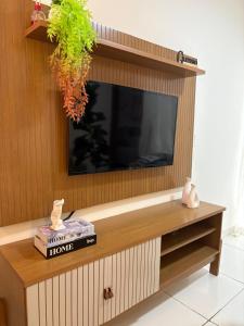un soggiorno con TV a schermo piatto su una parete in legno di REFUGIO DO CRUZEIRO - GRAVATa a Gravatá