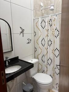 un bagno con un water, un lavandino e una tenda da doccia di REFUGIO DO CRUZEIRO - GRAVATa a Gravatá