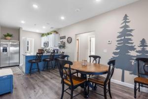 a kitchen and dining room with a table and trees on the wall at Crossroads Vistas - 3BDR Condo in Branson