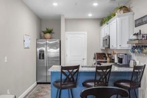 a kitchen with a refrigerator and a counter with chairs at Crossroads Vistas - 3BDR Condo in Branson