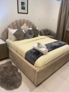 a large bed with a towel on top of it at Waves luxury in Accra