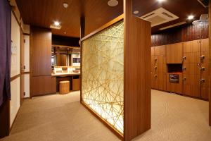 a room with a closet with a glass door at Dormy Inn Nagano in Nagano