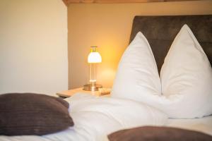 a bedroom with a bed with white pillows and a lamp at Gesundheitsbauernhof -Landhof - Offenbacher in Seckau