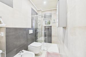 a white bathroom with a shower and a toilet at Attraktive Neubauwohnung,Balkone,WIFI,Parken im Hof,Ganze Ruhe in Bremen +3 photos