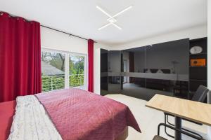 a bedroom with a bed and a table and a window at Attraktive Neubauwohnung,Balkone,WIFI,Parken im Hof,Ganze Ruhe in Bremen