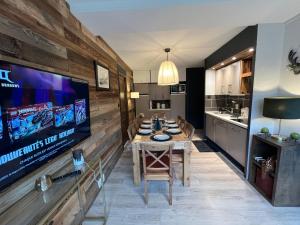 a dining room with a table and a flat screen tv at Mimi lodge familly in Valloire +21 photos