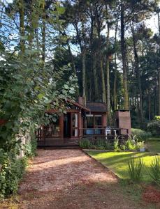 una cabina nel bosco con un vialetto di ghiaia di Cabaña Ceibo a Mar de las Pampas