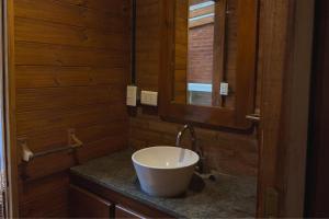 un bagno con un lavandino bianco e uno specchio di Cabaña Ceibo a Mar de las Pampas